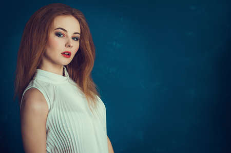 Close-up portrait beautiful girl on a blue backgroundの写真素材