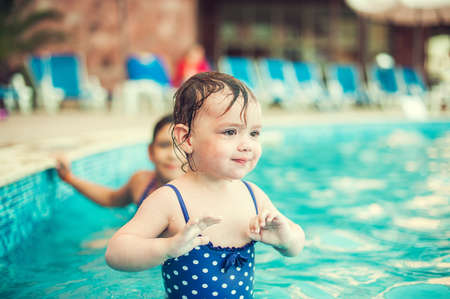 Happy child in swimming pool, beautiful girl swimsの写真素材