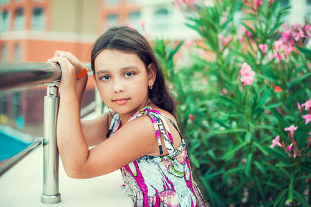 Beautiful little girl in dress standing in a hotelの写真素材