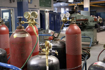 Closeup of pressure gauge and bottles in a welding shopの写真素材