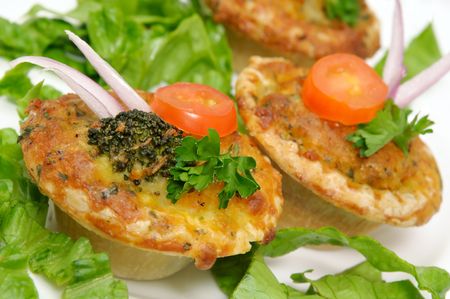 Small vegetable quiche decorated with onion, broccoli, tomato slice and parsleyの写真素材