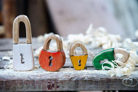 Handmade padlock painted wooden toy. On the wooden background with wooden shavings. Beautiful...