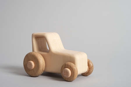 Wooden handmade toy tractor on light isolated backgroundの写真素材