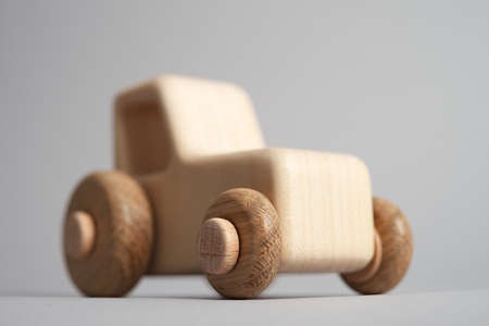 Wooden handmade toy tractor on light isolated backgroundの写真素材