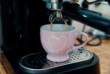Sweet morning at home - close up of coffee machine pouring espresso with soft backgroundの写真素材