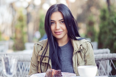 Portrait of a beautiful woman smiling outdoors on restaurant cafe coffee shop terrace outdoors as a backgroundの写真素材
