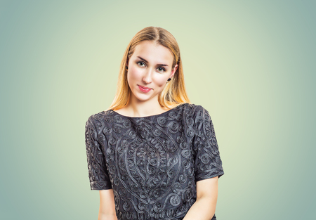 Portrait of modern confident blond woman wearing elegant ornamental blouse smiling at cameraの写真素材
