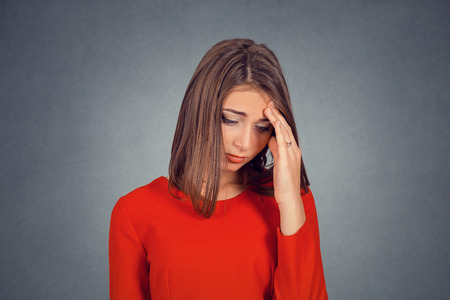 Depressed. Headshot of sad young woman. Business lady in red dress, bob hairstyle. Isolated on gray grey studio wall Background. Negative face expression human emotion body language reaction attitudeの写真素材