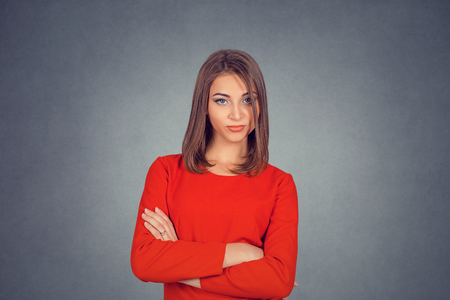 Jealous friend. Grumpy skeptical envious woman. Business woman in red dress, bob hairstyle. Isolated on gray grey studio wall Background. Negative face expression, human emotion body language reactionの写真素材