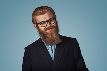 Portrait of handsome Bearded hipster businessman wearing glasses smiling happy Isolated on blue Background. Positive face expression, human emotion, body language, reaction, attitude. Studio shotの写真素材