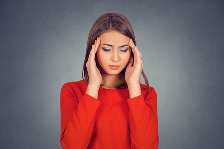 Closeup portrait sad young beautiful woman with worried stressed face expression looking down. Business lady in red dress, bob hairstyle. Isolated on gray grey studio wall Background. Negative emotionの写真素材