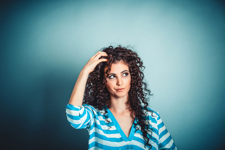 Portrait closeup funny confused skeptical woman girl female thinking with memory loss looking up isolated blue wall background copy space above head. Human expressions, emotions, feelings, body languageの写真素材