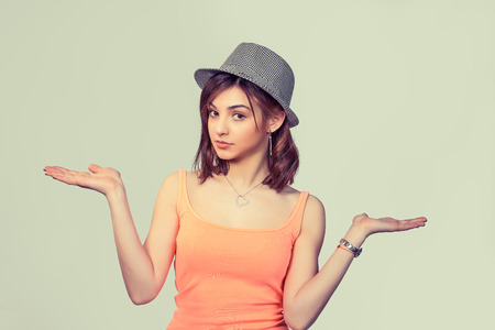 Closeup portrait of pretty angry unhappy young woman with arms out asking whats the problem who cares so what. Isolated on light green yellow background. Negative human emotions facial expressionの写真素材