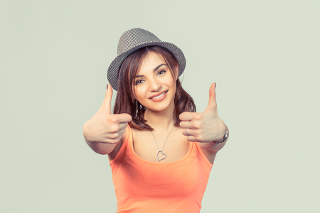 Closeup portrait young successful smiling woman student being excited giving thumbs up isolated light green background. Positive human emotions facial expressions feeling sign symbol attitudeの写真素材