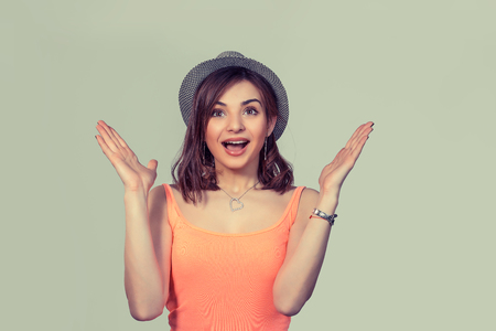 Lucky girl. Closeup portrait happy young woman happy exults hands up looking ecstatic isolated green wall background. Celebrate success concept. Human facial expression emotions feelings body languageの写真素材