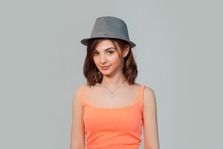 Woman smiling shy looking at you camera gray hat on head isolated on light grey background studio wallの写真素材