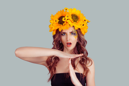 Young woman in sunflowers floral crown showing time out hand gesture, frustrated screaming to stop isolated on grey wall background. Too many things to do. Human emotions face expression reactionの写真素材