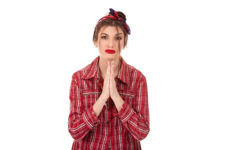 Head shot studio portrait millennial woman pose over white background looking at camera cupped hands in praying gesture feels sad desperate, symbol of asking apologizing, sincere saying please conceptの写真素材