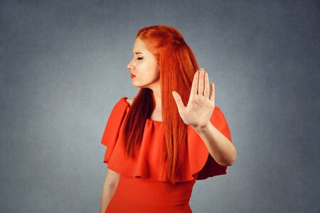 Redhead woman showing Stop, No gesture with hand on grey background