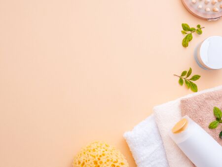 Natural cosmetics concept. Fresh green basil leaves, body shower gel, shampoo, massage tool, scrub...