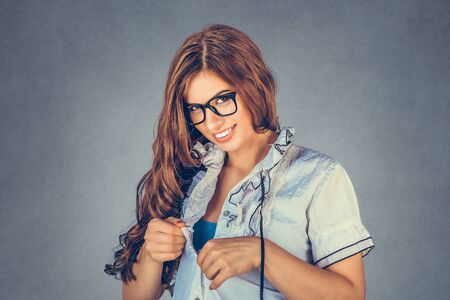 Adultery at the workplace. Sexy woman, secretary wearing white formal buttoned shirt undressing herself, looking sexy and flirty. Mixed race model isolated on gray, grey background with copy space.の写真素材