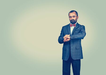 Businessman looking on his watch. Standing one single person man with modern, dark suit, white...