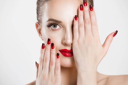 Sexy Beauty Girl with false eyelashes Black Red gradient Lips, Nails. Provocative natural Make up. Luxury Woman looking at you camera hands on face Fashion Brunette Portrait isolated white backgroundの写真素材