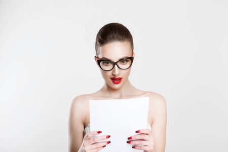 Astonished with her monthly statement. Actress looking amazed at role lines, bride surprised with her prenuptial marital wedding contract. Beautiful happy brunette girl on white light grey backgroundの写真素材