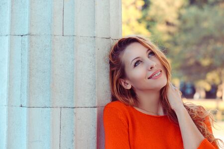 Close up lifestyle portrait of cute pretty young woman posing outdoor, looking up. isolated street background with copy spaceの写真素材
