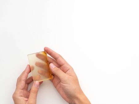 Hands holding natural soap isolated on white background. Wash your hands concept.