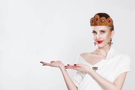 Happy smiling beautiful young woman shows hands pointing to the side â isolated white background with copy spaceの写真素材
