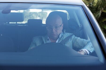 Shocked scared anxious funny looking young driver in the car. Human emotion face expression. Front...