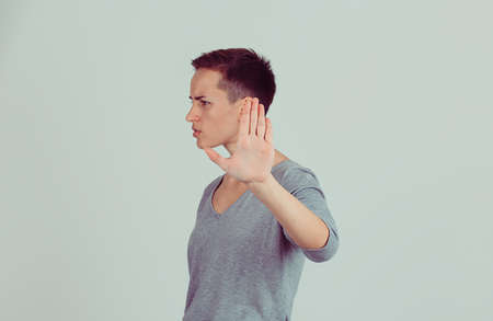 Closeup portrait young annoyed angry woman with bad attitude giving talk to hand gesture  palm outward isolated light green grey wall background. Negative human emotion face expression body languageの写真素材