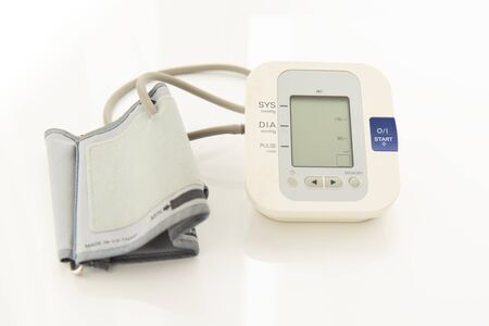 Medical electronic tonometer on white medical table as a background. Risk for cardiology desease,...
