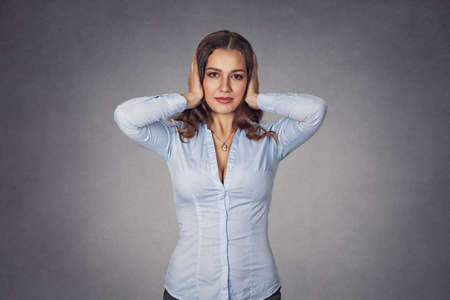 Portrait of young happy attractive casual woman covering with hands her ears eyes opened isolated on...