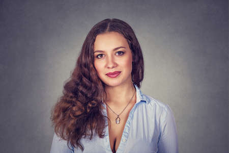 Happy, cheerful, smiling woman isolated on studio gray background. Model girl with long wavy curly...