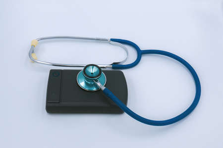 External Computer hard drive and a stethoscope  on a white background. Repair hard drive business conceptの写真素材