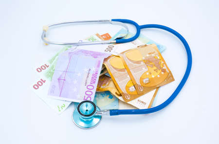 Blue stethoscope is around European cash euro money isolated on a white background. Financial business conceptの写真素材