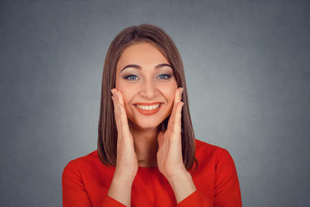 Closeup portrait of happy cute young woman in red dress looking excited surprised in full disbelief...