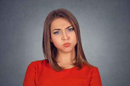Closeup portrait of angry young woman with swollen puffing cheeks jaws blowing air steam nervous or...