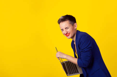 Closeup portrait happy young business woman laughing loud holding laptop portable computer isolated...