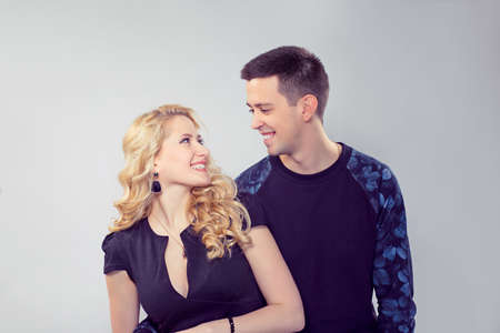 Content happy man and beautiful woman embracing and looking at each other with love