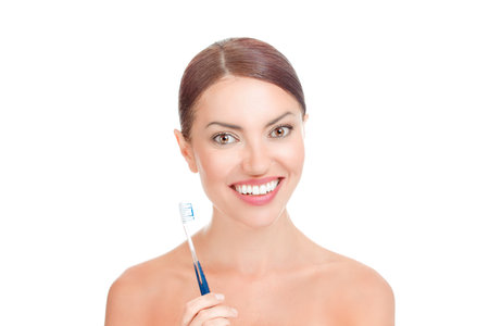 Happy young woman holding toothbrush smiling isolated on white background. Mixed race latina hispanic african american caucasian model. Positive face expressionの写真素材