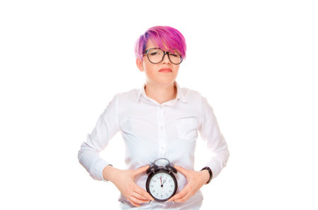 Unhappy woman smiling sadly holding a clock at belly showing that her biological watch is ticking....