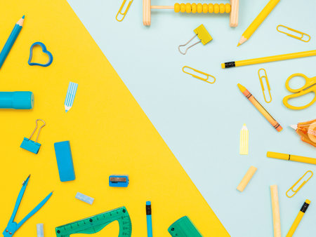 Back to school, education concept. Blue stationery tools and yellow school tools isolated on dual color yellow and blue studio background with copy space. Flat lay, view from top.の写真素材
