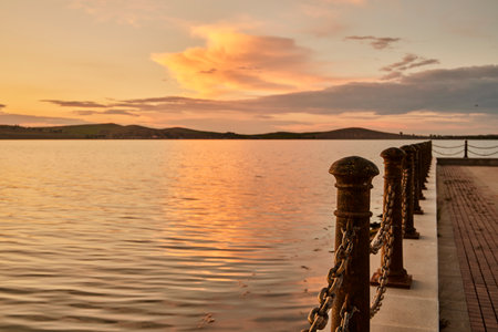 Beautiful sunset on the lake with clouds and mountains in the backgroundの写真素材