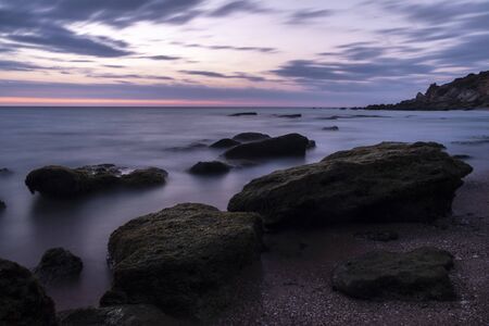 Photography of the sea at the blue hour with rocks.