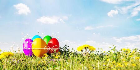 Easter colorful eggs on green grass under the blue sky 3D Rendering