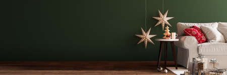 Christmas tree decoration in living room interior with copyspace on green wallの写真素材