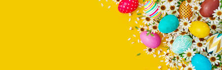 Colorful eggs with white spring flowers and decoration on yellow Easter background 3D Rendering, 3D...